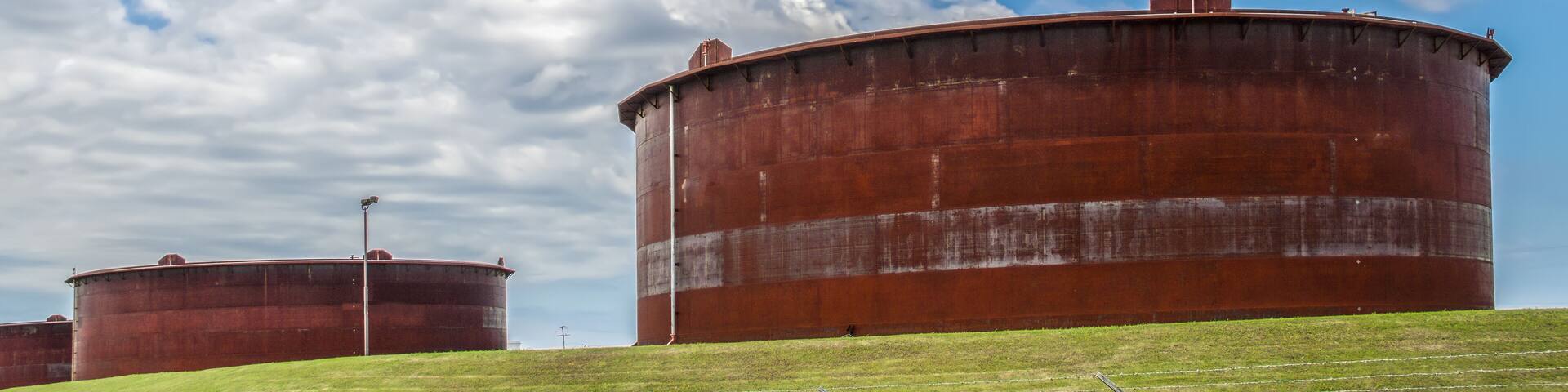 Huge rusty storage tanks full of petroleum products in tank farm in Cushing Oklahoma where most oil in USA is stored and traded