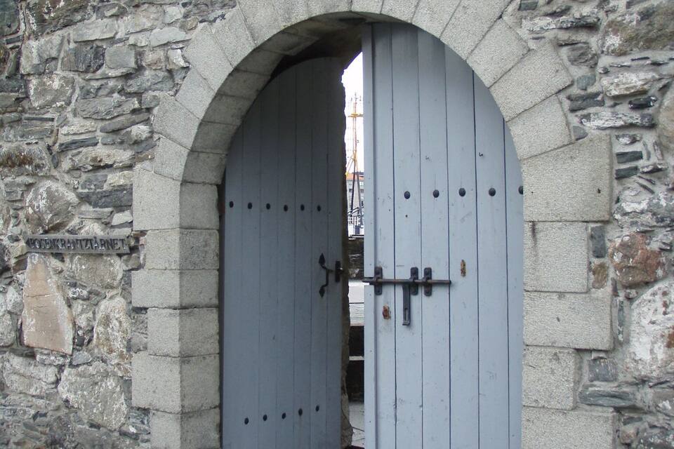 Um arco de pedra com uma porta de madeira.