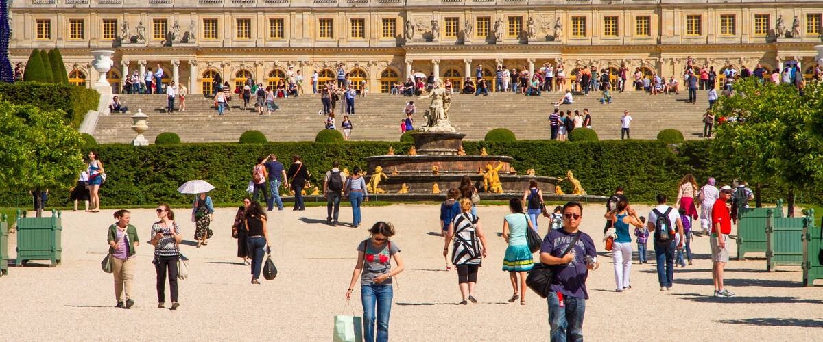 A historic palace with ornate architecture and a large crowd of visitors.