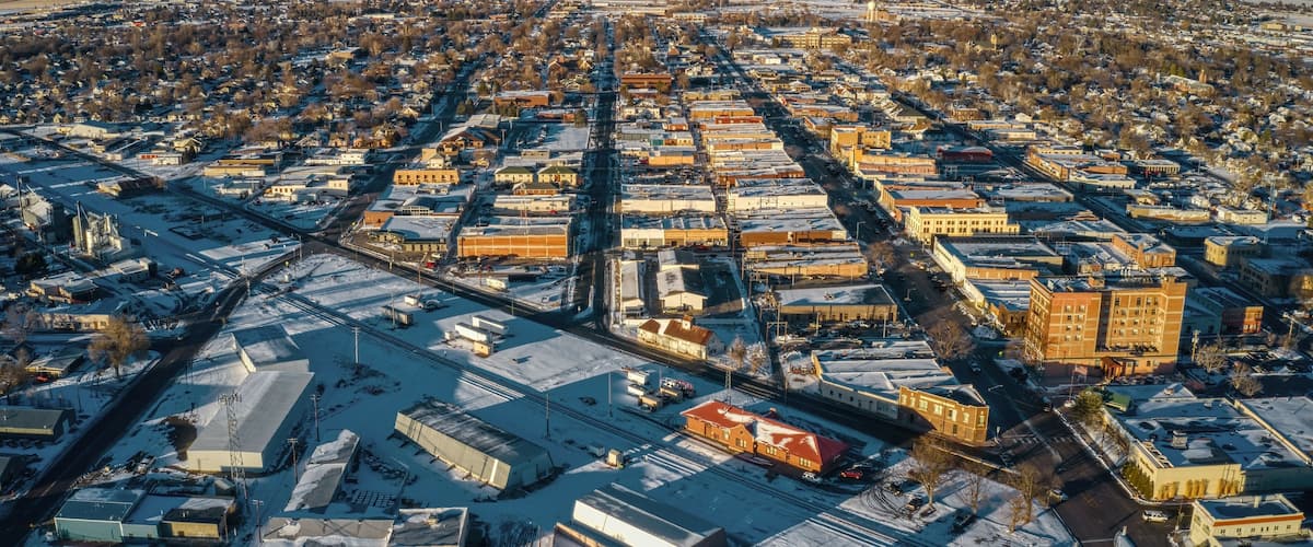 An aerial view of a city with snow-covered streets and buildings.