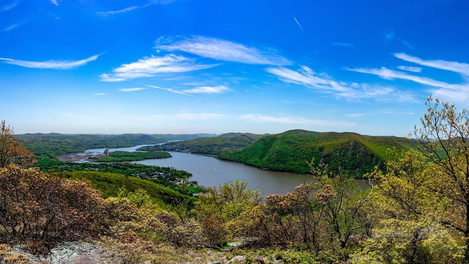 A river winding through green hills under a clear blue sky.
