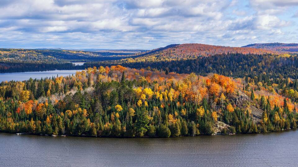 A lake surrounded by forested hills with autumn foliage.