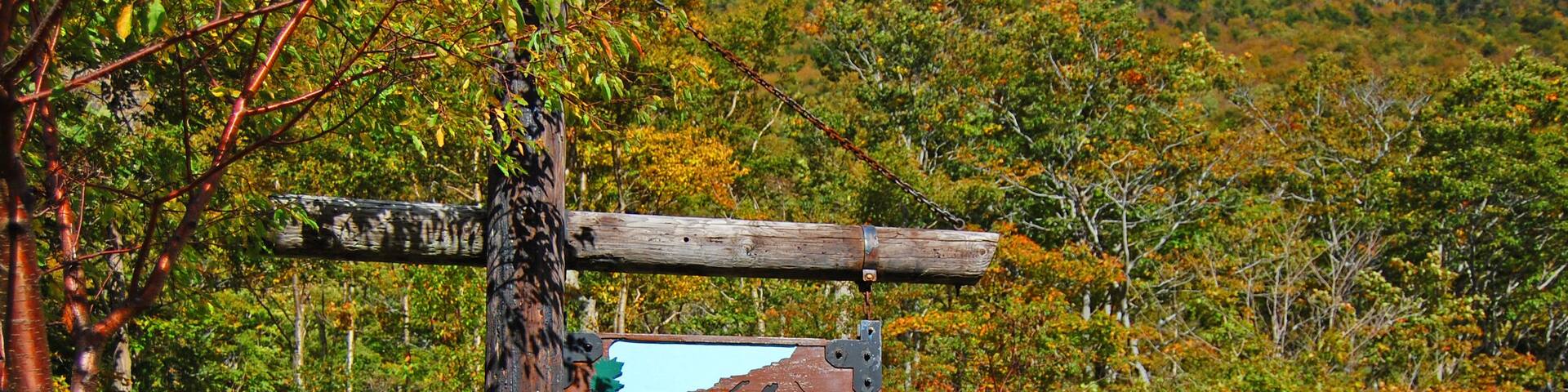 Franconia Notch with fall foliage and Old Man of the Mountain sign in Franconia Notch State Park in White Mountain National Forest, near Lincoln, New Hampshire NH, USA.