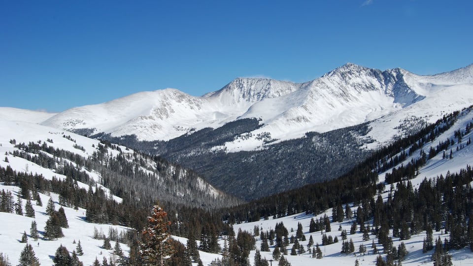 A snow-covered mountain range with clear blue skies.