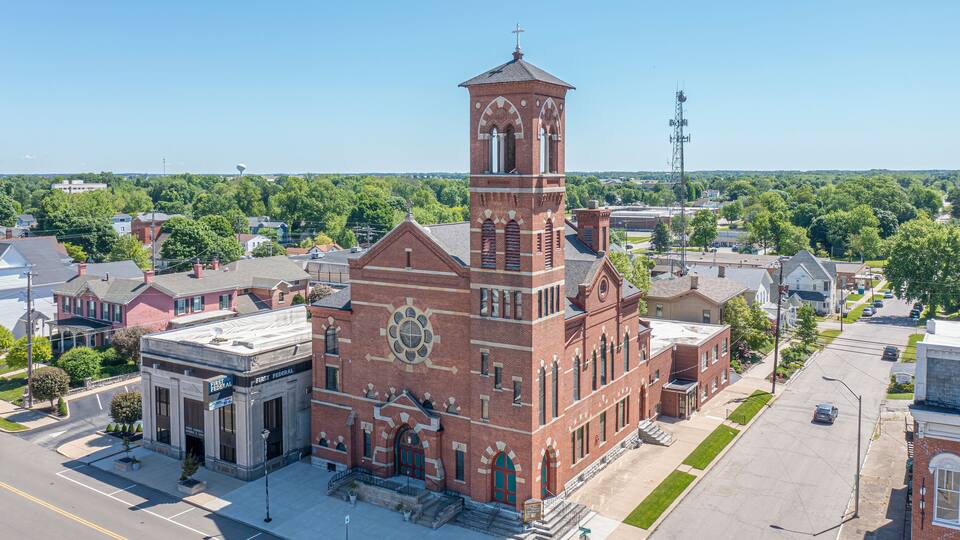 A large brick church with a prominent tower and a clock.