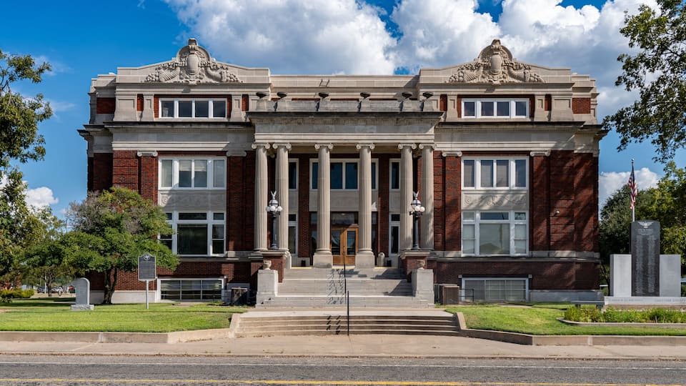 A historic building with a grand entrance, columns, and decorative elements.