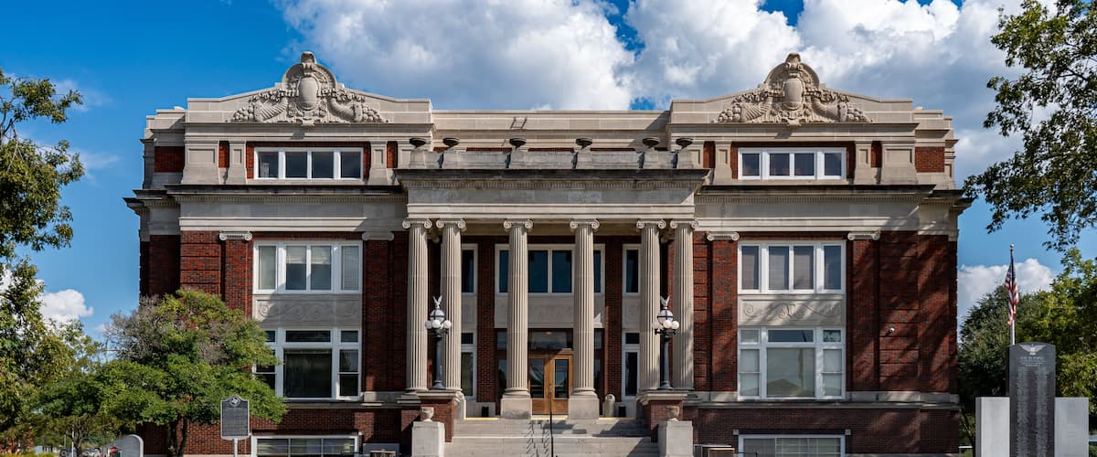 A historic building with a grand entrance, columns, and decorative elements.