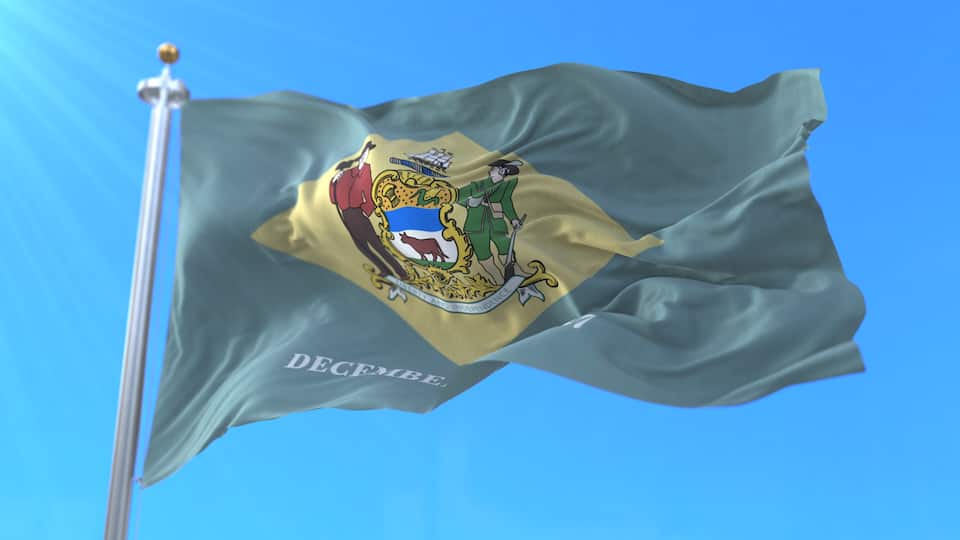 A flag with a coat of arms featuring a ship, a lion, and a person with a sword.