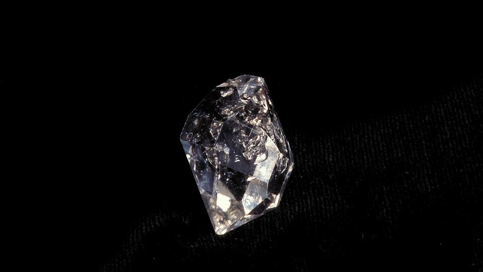 A faceted gemstone on a black background.