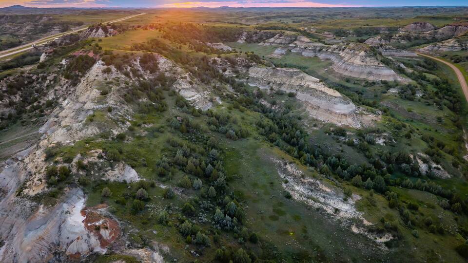 A rugged landscape with rolling hills and a winding road.