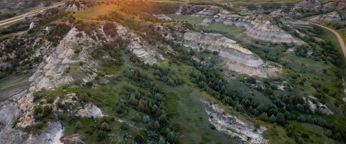 A rugged landscape with rolling hills and a winding road.