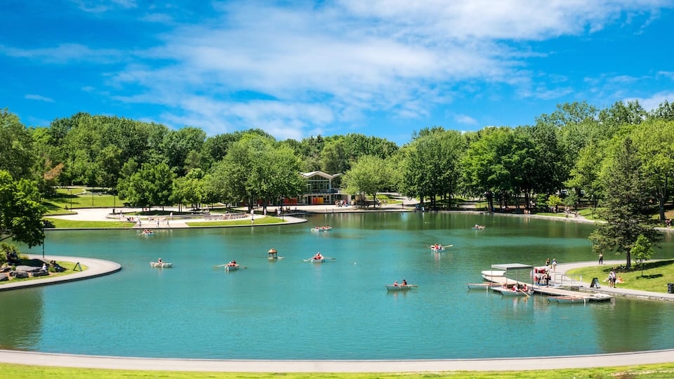 A large lake surrounded by trees and a building with a modern design.