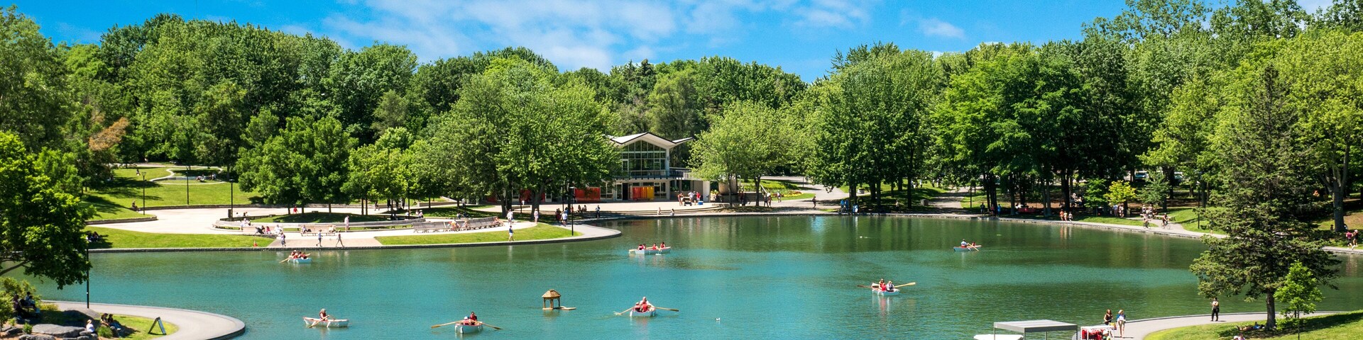 Un lago extenso rodeado de árboles y un edificio de diseño moderno.