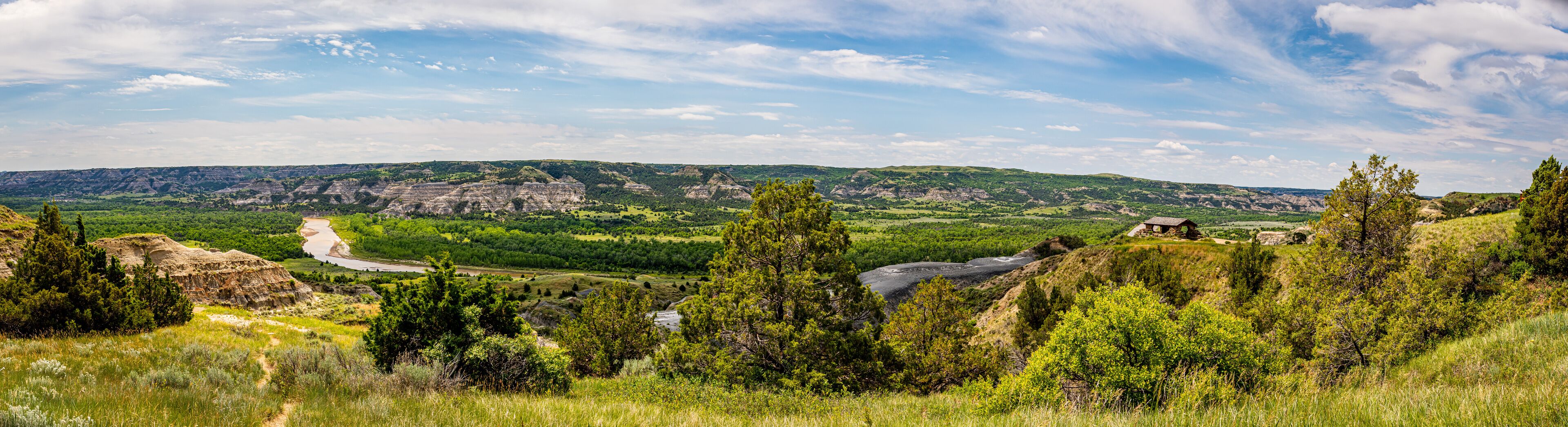 A river winding through a valley with green hills and rocky outcrops.