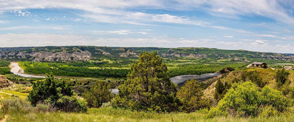 A river winding through a valley with green hills and rocky outcrops.