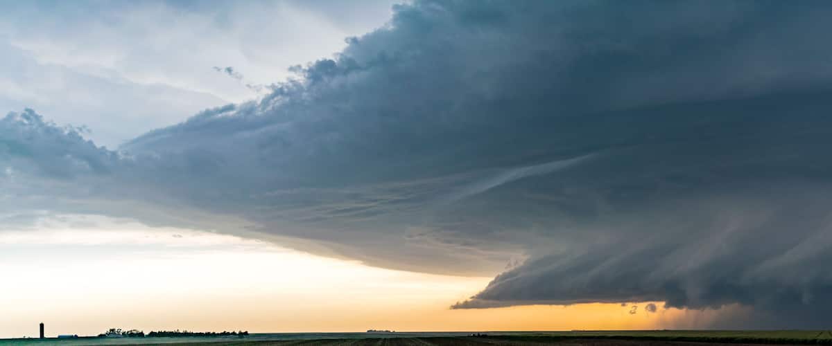 A tornado over a flat landscape with a distant horizon.