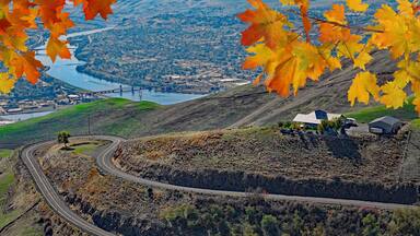 View of Lewiston, Idaho and Clarkston, Wa from the Lewiston Hill overlook framed by fall maple leaves