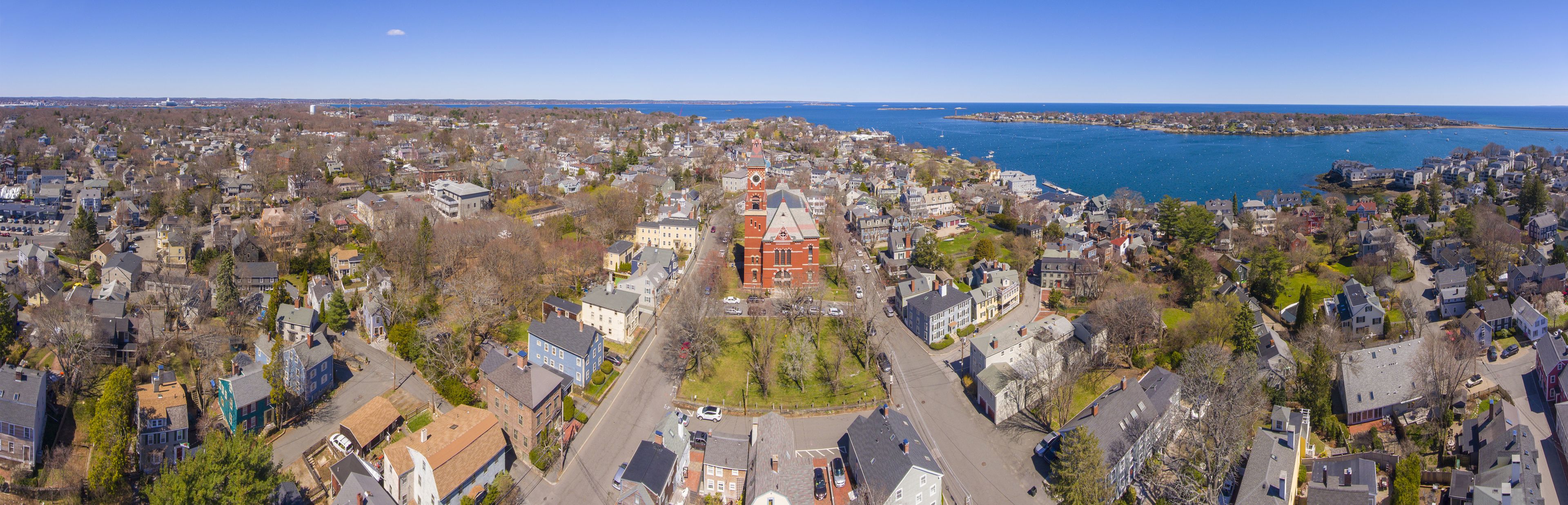 A coastal town with a prominent red church, dense residential areas, and a large body of water.