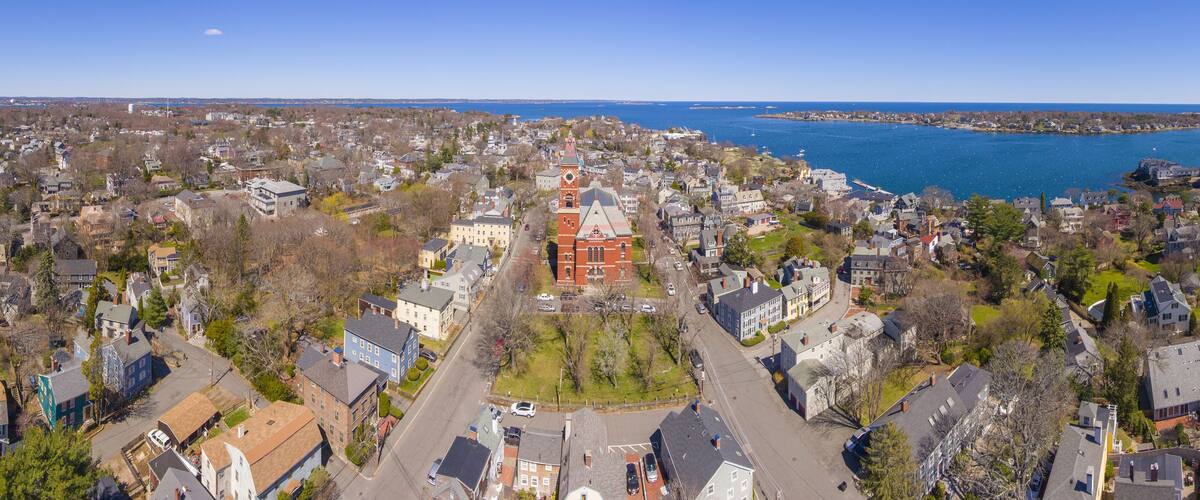 A coastal town with a prominent red church, dense residential areas, and a large body of water.