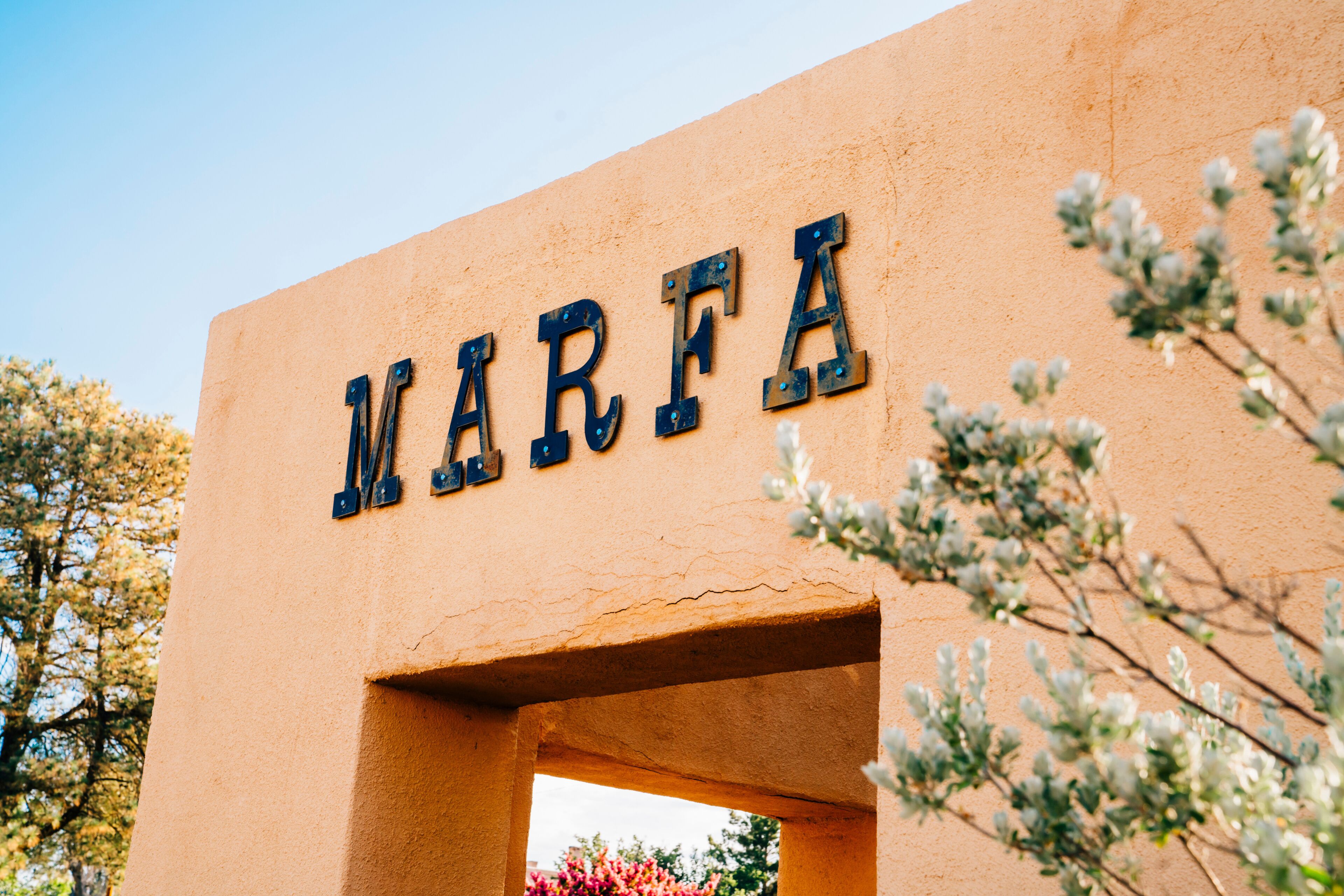Sign for Marfa, Texas on side of stucco wall in park