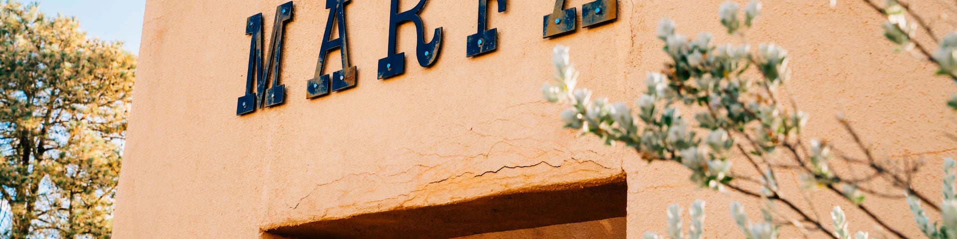 Sign for Marfa, Texas on side of stucco wall in park