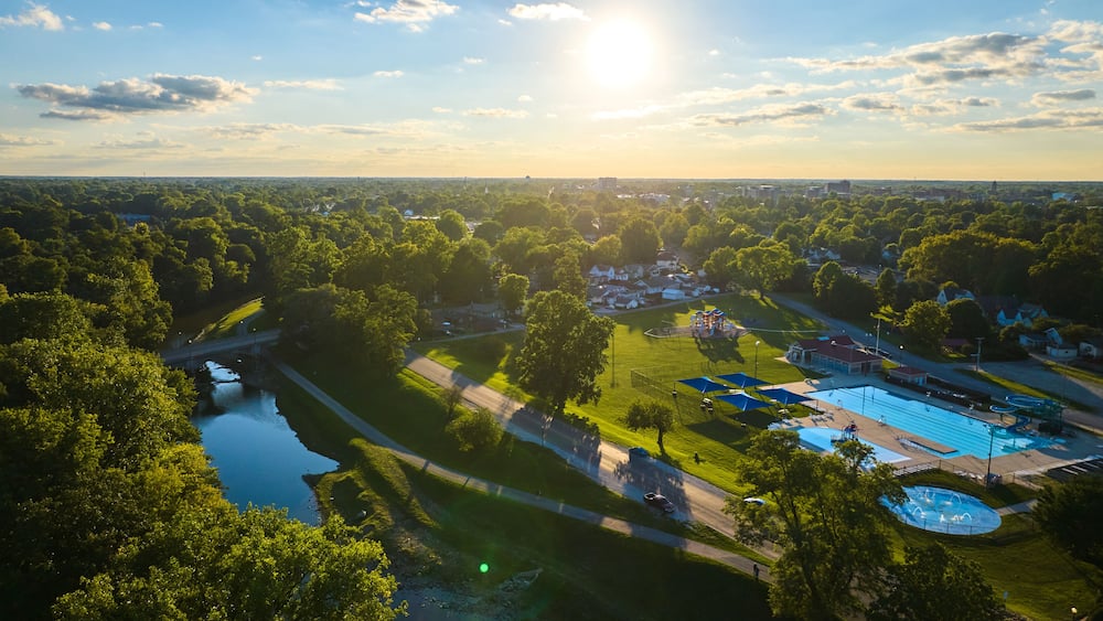 Tuhey Pool aerial in late afternoon with golden sunshine over neighborhood and White River, Muncie
