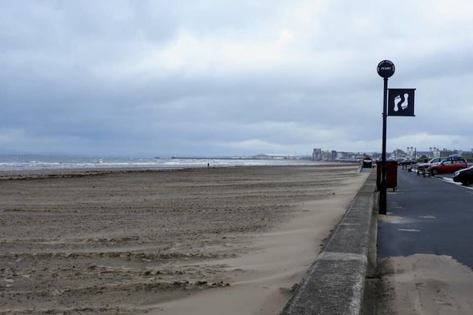 A beach with a pedestrian path and a 'Start' sign.