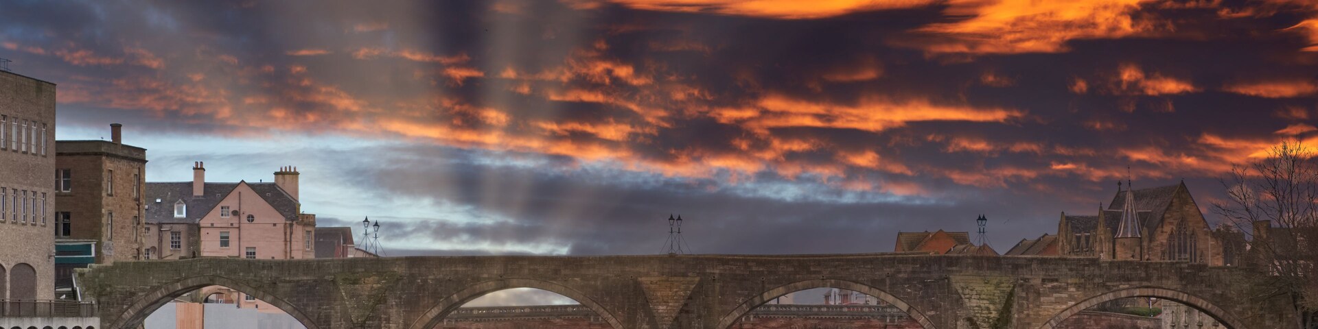 The Auld (Old) Brigg in Ayr in Scotland Dramatic Sunset over the Burn's Town