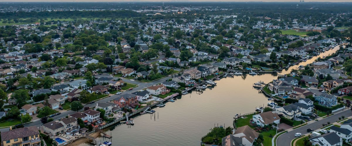 An aerial view of a residential area with a river and docks.