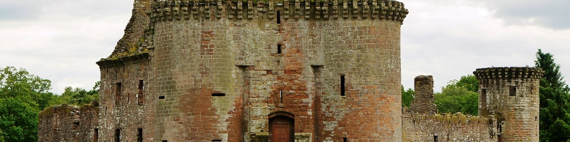 Un castillo histórico con una torre central, varias torres más pequeñas y una gran entrada en arco.