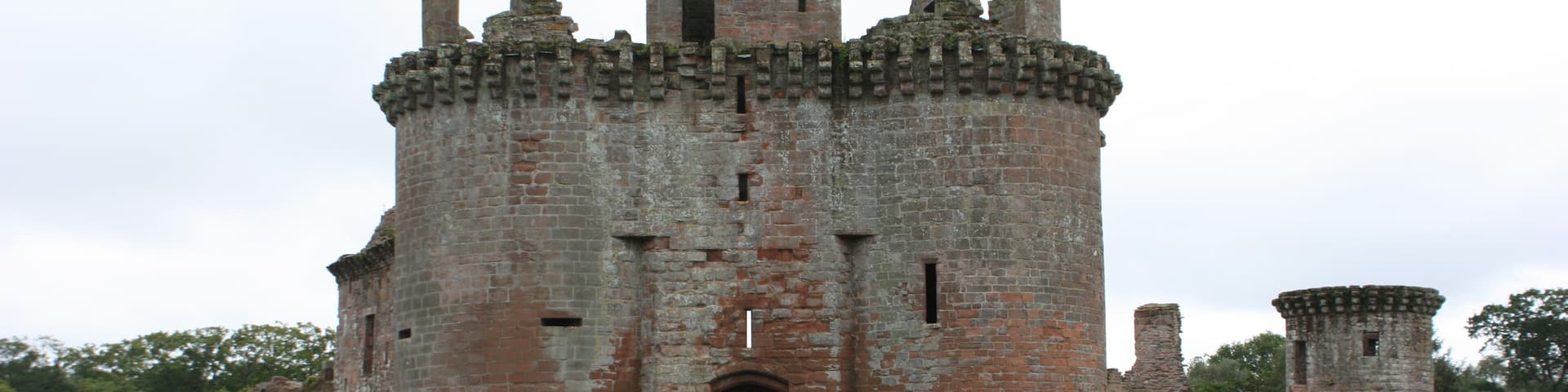 A historic castle with a central tower, arched entrance, and surrounding walls.