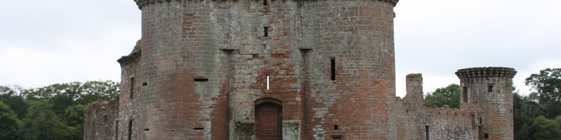 A historic castle with a central tower, arched entrance, and surrounding walls.