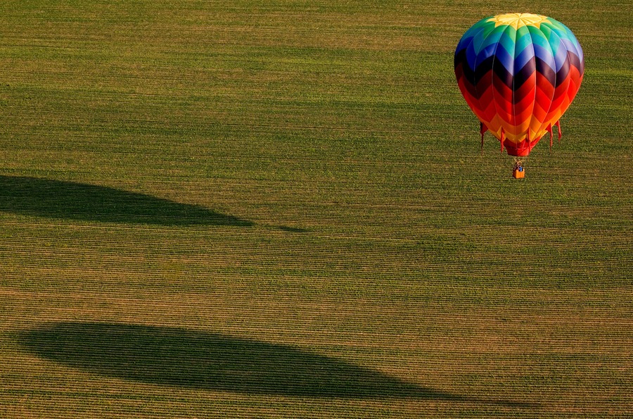 A colorful hot air balloon over a field.