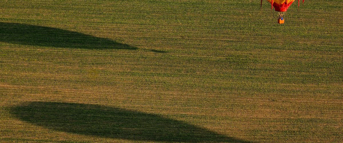 A colorful hot air balloon over a field.