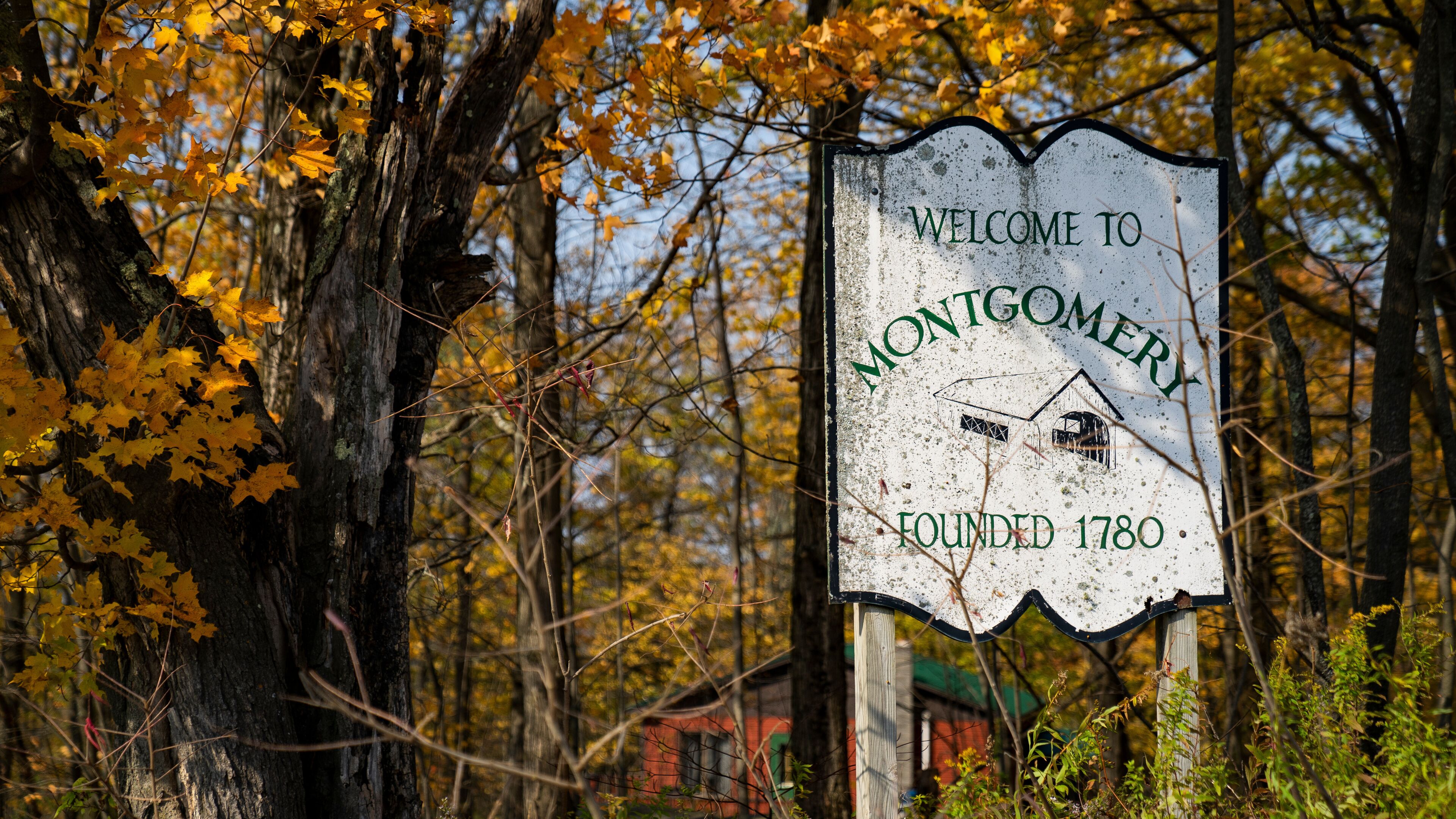 Montgomery, Vermont old sign with fall foliage landscape background