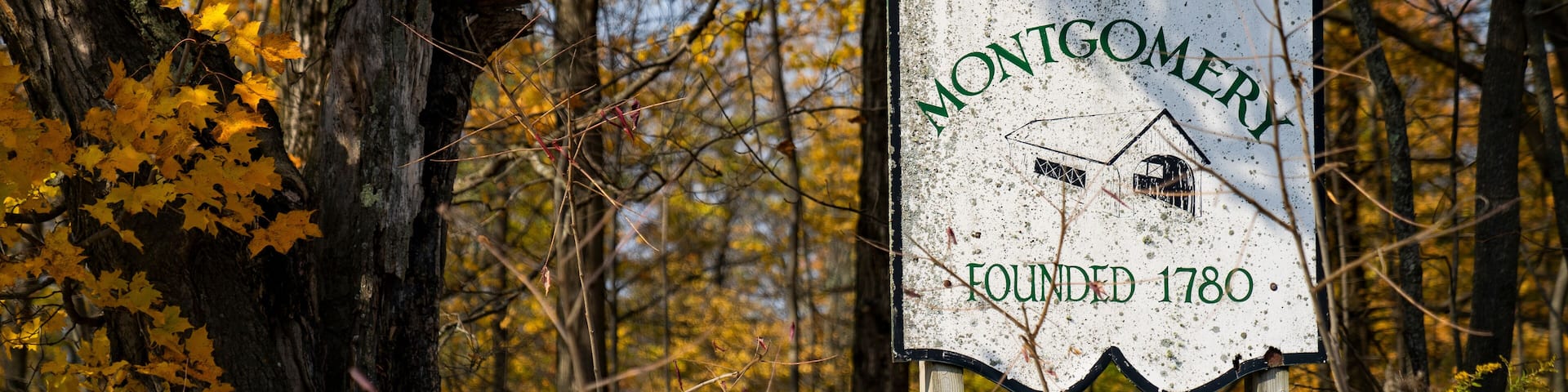 Montgomery, Vermont old sign with fall foliage landscape background