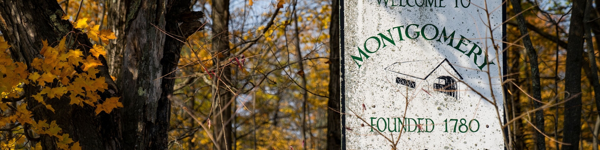 Montgomery, Vermont old sign with fall foliage landscape background