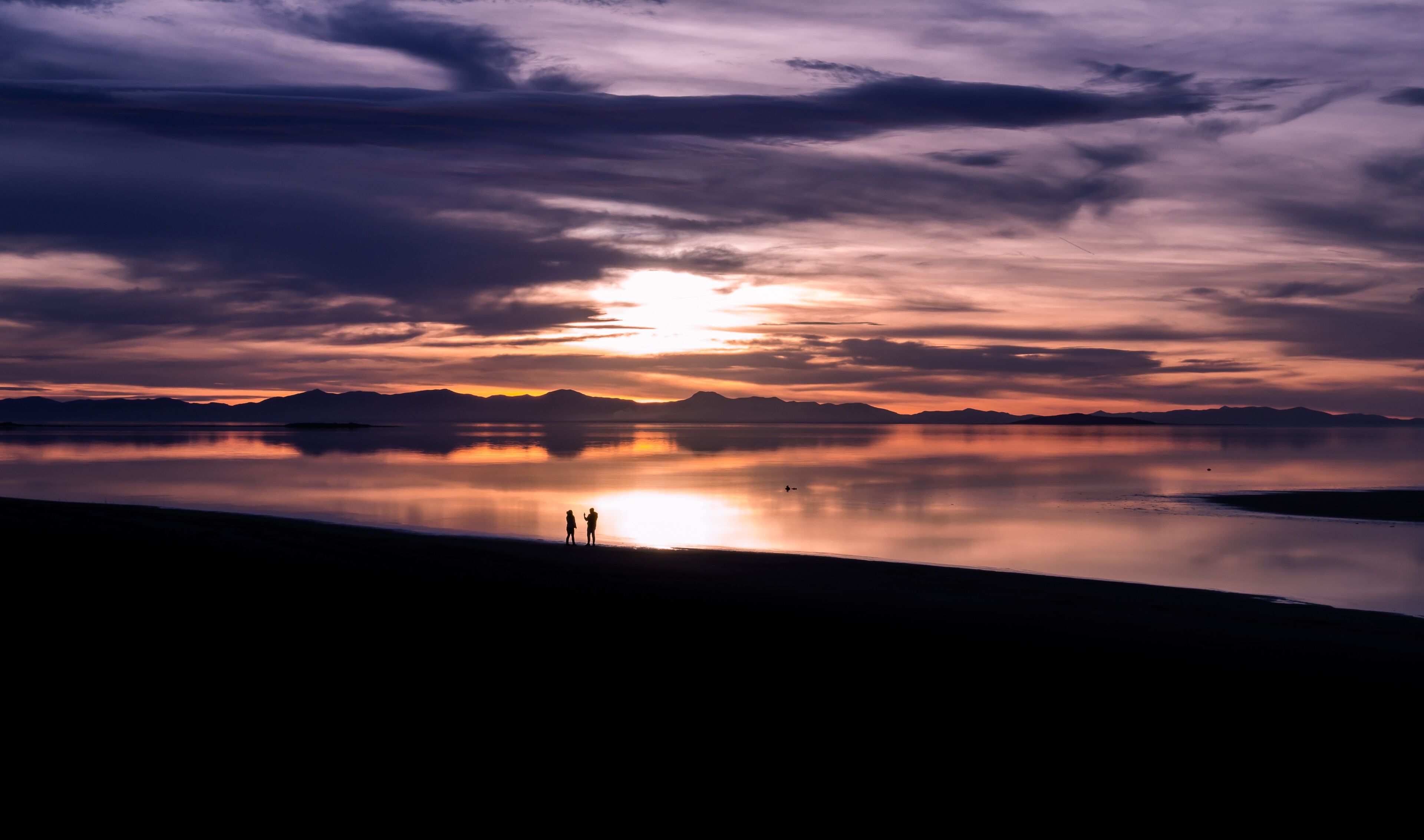 Great Salt Lake sunset with couple silhouettes and reflection
