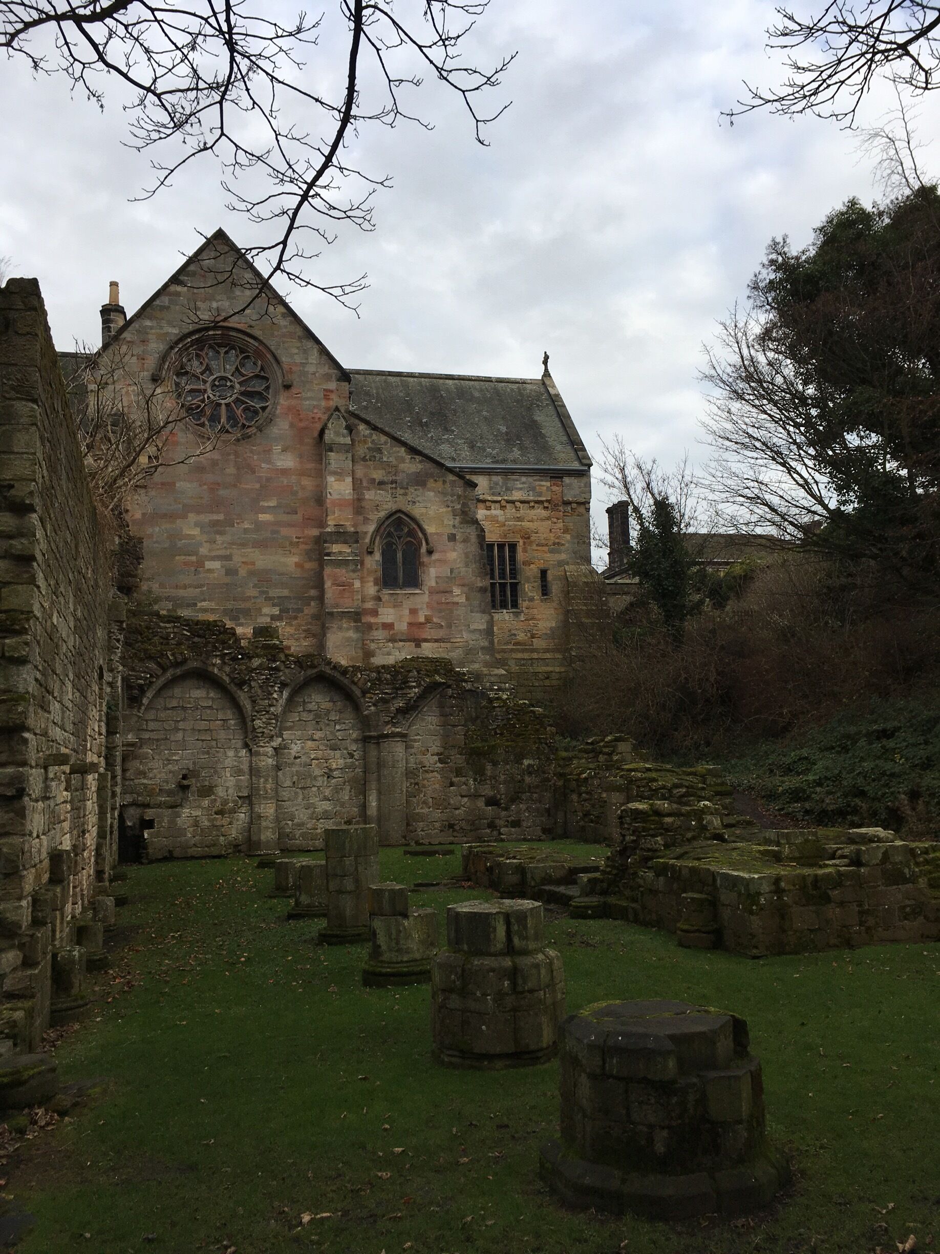 An old stone building with a large circular window and arched doorways.