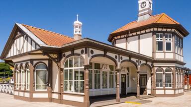 A historic building with a clock tower, arched windows, and a tiled roof.