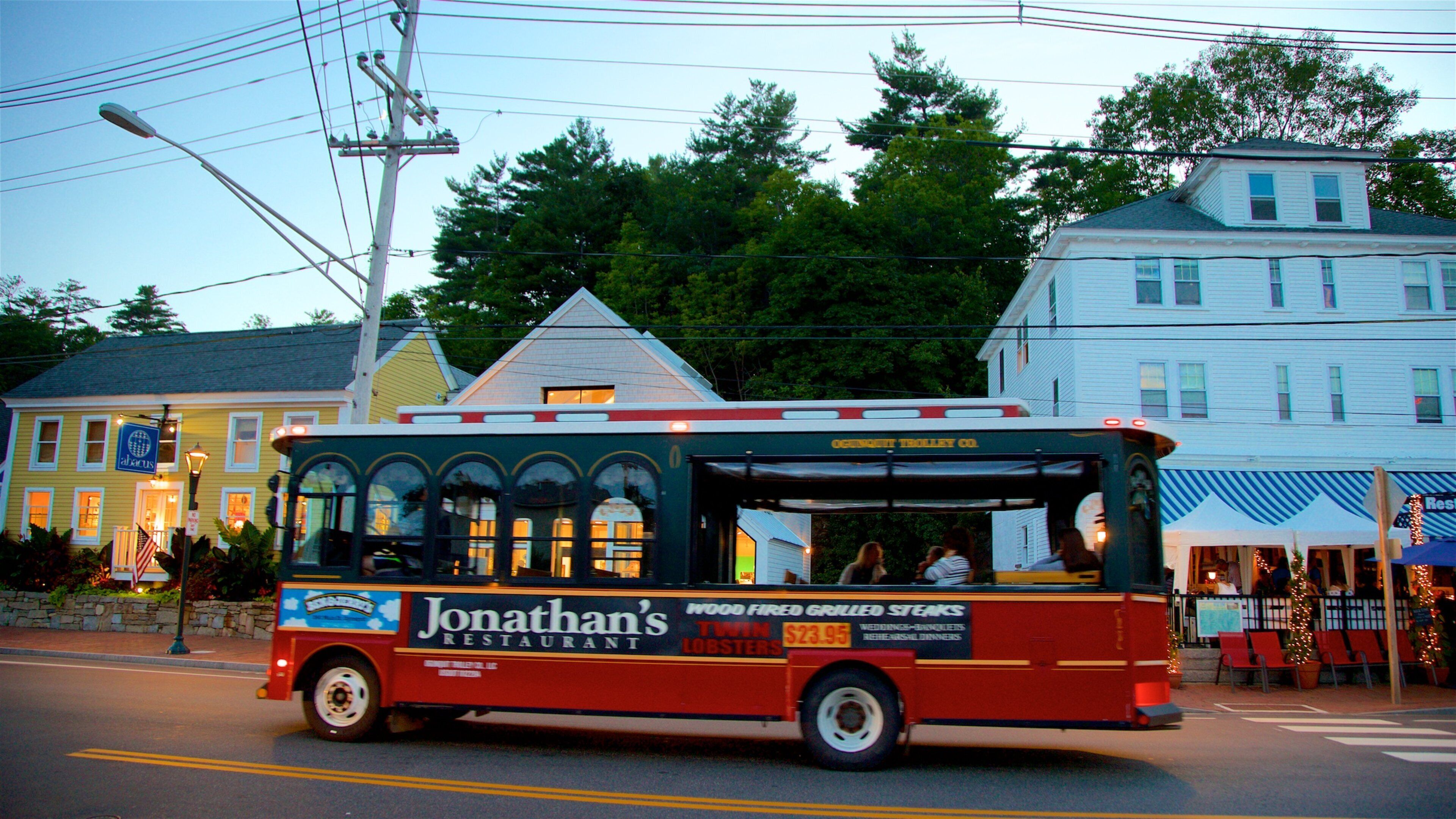 A red and blue bus with "Jonathan's Restaurant" and "Twin Lobsters" advertisements parked on a street.