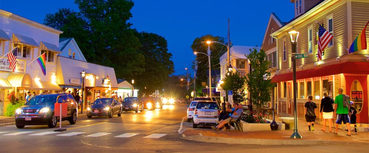 A street lined with shops and restaurants at dusk.