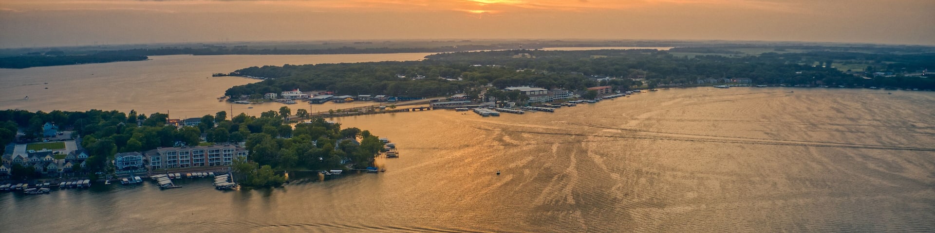 A river with boats, a dock, and buildings along the shore.