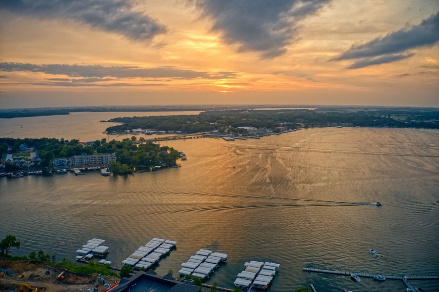 A river with boats, a dock, and buildings along the shore.