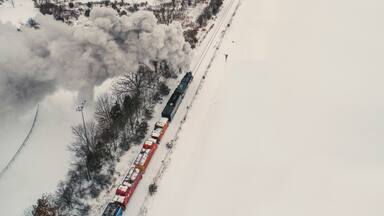 High angle view of train moving on snow covered railroad track