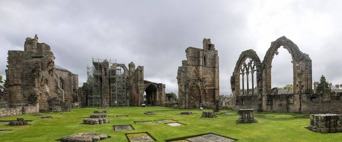 The ruins of a medieval castle with Gothic arches and stone walls.