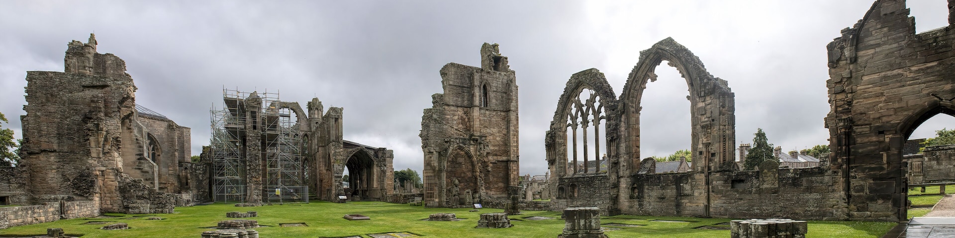 The ruins of a medieval castle with Gothic arches and stone walls.