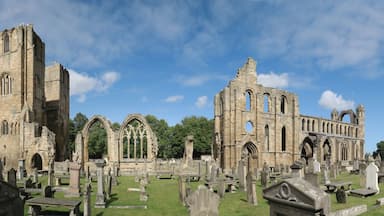 A historic church with Gothic architecture and a cemetery in the foreground.
