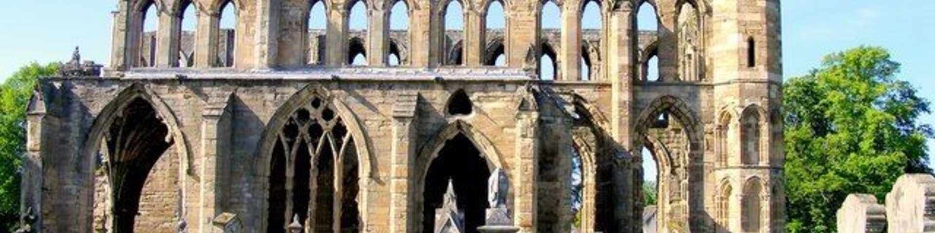 Una antigua estructura de piedra con varios arcos y una torre alta.