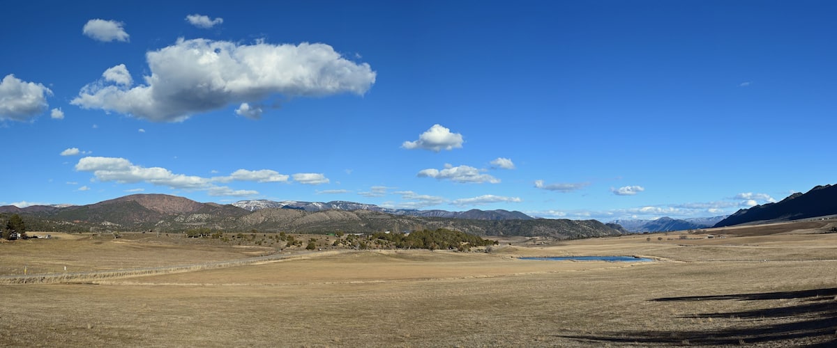 Panoramic view of agricultural fields of Grass Valley in Garfield County, Colorado on sunny winter morning.